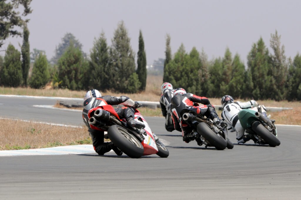 Motorcycle racers leaning through a bend on a paved track